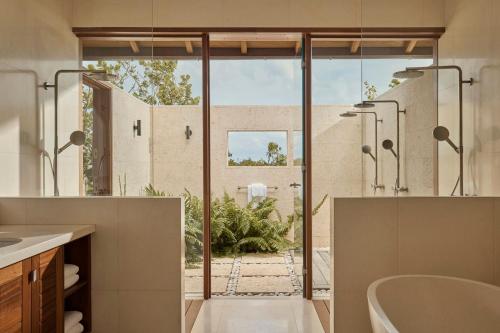 Sandy Point鹦鹉洲COMO酒店的带浴缸的浴室和大窗户