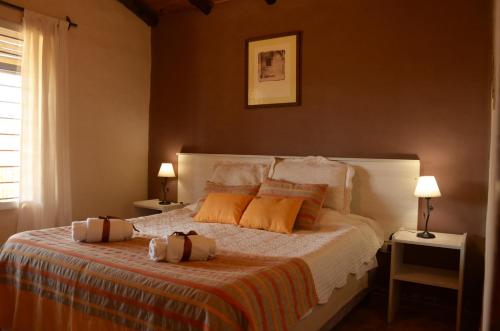 圣拉斐尔Cabañas Bella Alba的一间卧室配有带橙色枕头的床