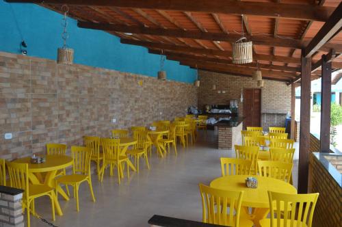 马拉戈日Pousada Vovó Zilda Maragogi的用餐室配有黄色的桌椅