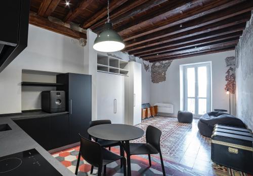 贝加莫Piazza Mascheroni Home的厨房以及带桌椅的起居室。