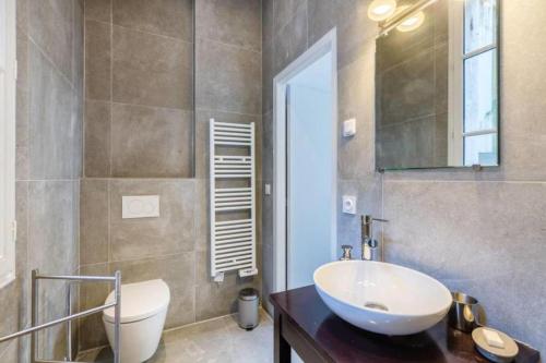 波尔多Magnifique Appartement avec climatisation en Hyper Centre de Bordeaux的一间带水槽、卫生间和镜子的浴室
