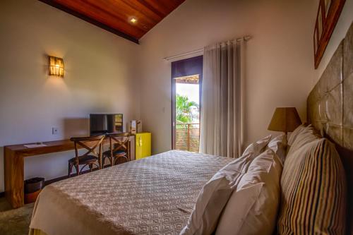 阿拉卡茹奥瑞纳生态海滩酒店的一间卧室配有一张床、一张书桌和一个窗户。