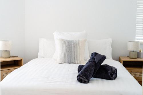 珀斯Cottesloe Beach View Apartments #11的一张白色的床,上面有两对袜子