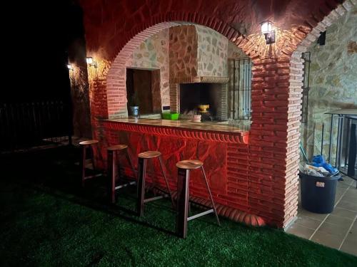 穆尔西亚Villa parque natural的砖砌建筑中带凳子的室外酒吧