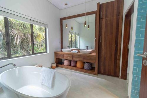 维兰库卢什VillaOne@Tsai-Tsai的带浴缸、两个盥洗盆和镜子的浴室