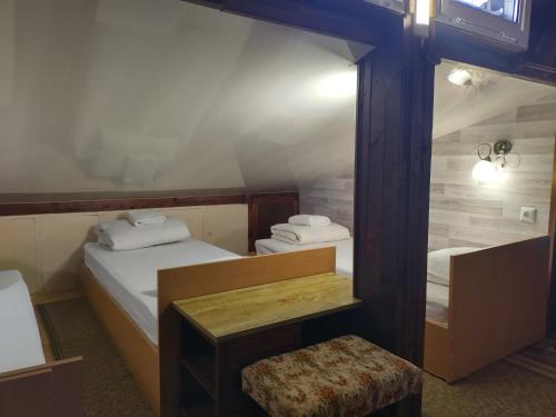 BrestnikКъща за гости Вишнева градина的一间卧室配有两张床和一张凳子。