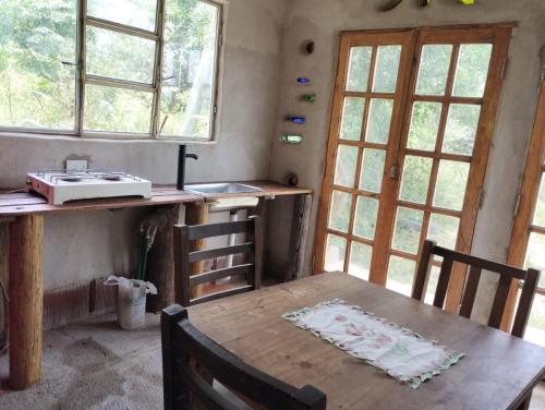 坦季ECO-LOFT, Sombra de Chañar,- Mallín Córdoba的厨房配有木桌和一些窗户。