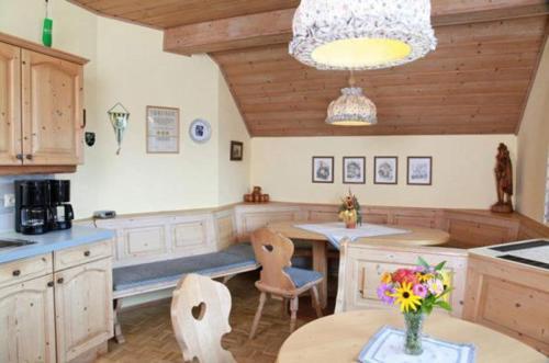 Kirchbach舒斯特尔旅馆的厨房配有桌椅和鲜花桌