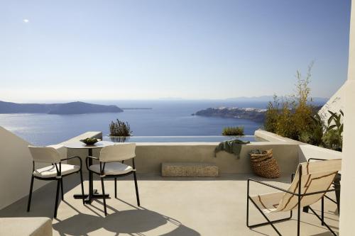 易莫洛林Atoles Retreat的一个带桌椅的庭院,俯瞰着大海