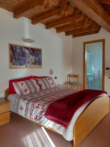 罗阿纳Alloggio Turistico Bufera的一间卧室配有一张带红色枕头的大床