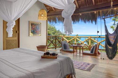 QuimixtoXinalani Retreat Mexico的一间卧室配有一张床,享有海景