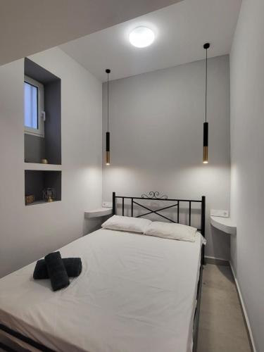 埃尔莫波利斯Evangelia's Cozy House的一间卧室配有一张白色的床和黑色床头板