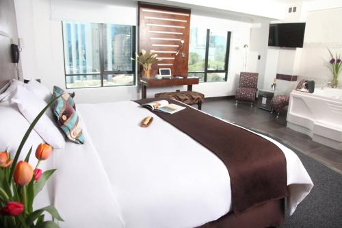 利马Hotel Rivera Inn的卧室配有白色的床和大窗户