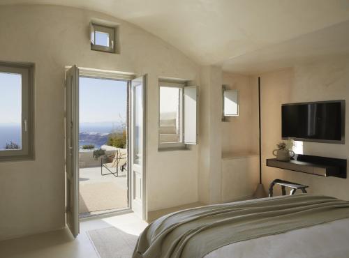 易莫洛林Atoles Retreat的一间卧室设有一张带电视的床和一个阳台。