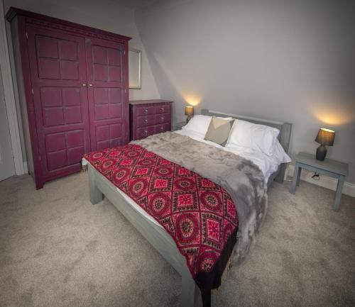 凯西克Loft Apartment, Keswick的一间卧室设有一张大床和红色的门