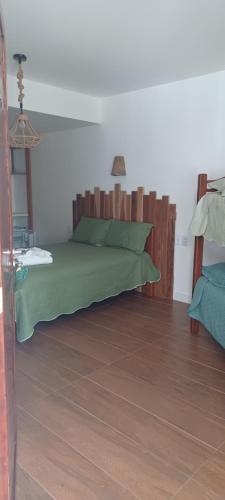 康德Pousada Neptun的一间卧室配有一张绿色的床和木制床头板