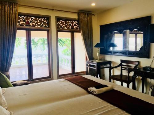 BantenKeraton Krakatoa的一间卧室配有一张大床、一张书桌和窗户。