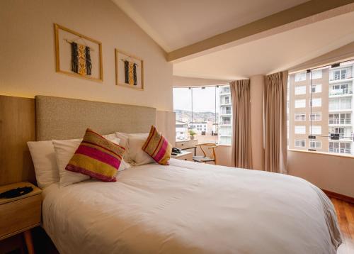 库斯科Torre Dorada Cusco的卧室配有白色的床和大窗户