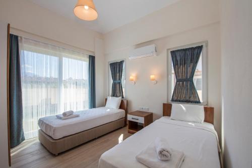 费特希耶SunTeos Villa Suites的酒店客房设有两张床和窗户。