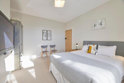 科布里奇Host & Stay - The Cottage in Corbridge的一间卧室配有一张大床和一台平面电视