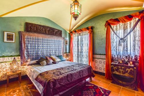 Villamayor de CamposCasa del Trotamundos的一间卧室配有一张床、吊灯和窗户。