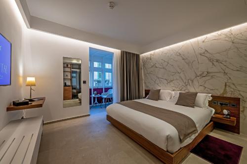 瓦莱塔The Capital Boutique Hotel的一间卧室设有一张带大理石墙的大床