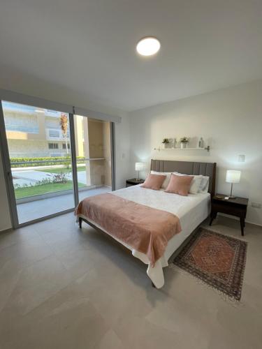 圣佩德罗-德马科里斯Exclusivo apartamento frente al mar的一间卧室设有一张大床和一个大窗户