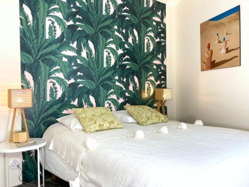 拉罗谢尔La Siesta的一间卧室配有一张大床,拥有绿色和白色的壁纸