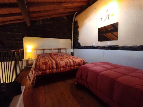 卡塔尼亚西塔艾马尔住宿加早餐旅馆的一间铺有木地板的客房内配有两张床的卧室