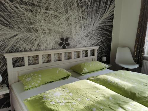 滕宁Gästehaus Arkona的一间卧室配有两张带绿色枕头的床
