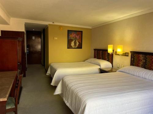 萨卡特卡斯Arroyo Express的一间酒店客房,设有两张床和走廊