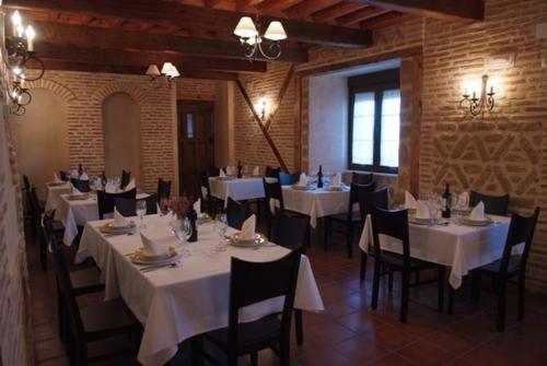 Villarmentero de Campos拉卡松纳德多尼亚佩特拉酒店的用餐室配有白色桌子和黑色椅子
