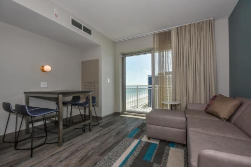 默特尔比奇Residence Inn by Marriott Myrtle Beach Oceanfront的带沙发和桌子的客厅以及阳台。