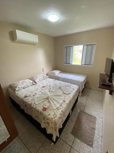 新艾朗Casa Bouganville的一间卧室设有两张床和窗户。