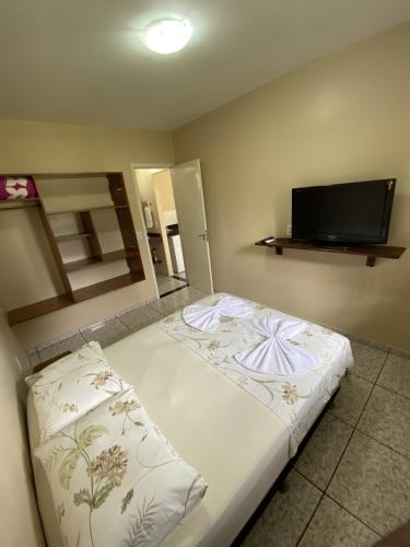 新艾朗Casa Bouganville的一间卧室配有一张床和一台平面电视