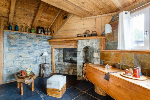 马尼戈Le Hameau de mon Père的小屋内带石头壁炉的客厅