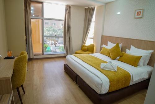阿尤恩Sahariano hotel City Center的配有一张床、一张书桌和一扇窗户的酒店客房