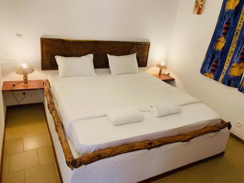 斯基灵角Villa Nemocotier的一间卧室配有一张带白色床单和两盏灯的床。