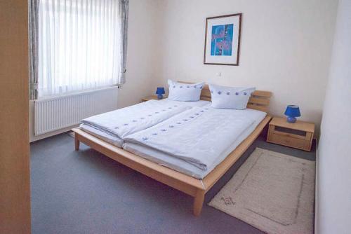 巴特柯尼希Haus Ulla的一间卧室配有一张带白色床单的大床
