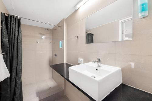 布里斯班Alloggio Hamilton Brisbane Airport的白色的浴室设有水槽和镜子