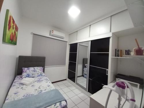 萨尔瓦多Village - Condomínio Mansão da Lagoa的一间小卧室,配有一张床和镜子