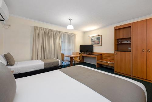 布里斯班飞马汽车旅馆及服务式公寓的酒店客房配有两张床和一张书桌