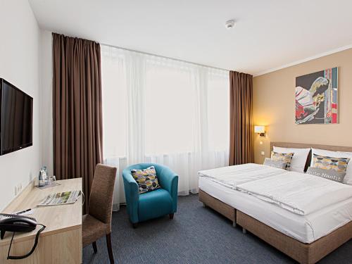 汉堡汉堡BO酒店的酒店客房配有一张床、一张桌子和一把椅子。