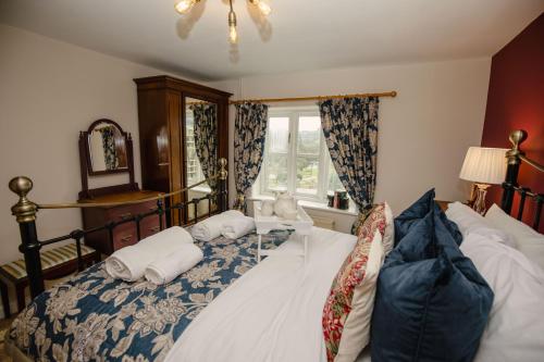 布里德波特Milkmaids Cottage - Rudge Farm Cottages的一间卧室设有一张床和一个窗口