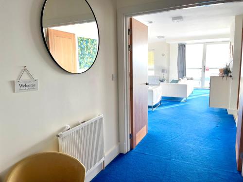 浦耳Quay & Sea View Spacious Modern Secure Parking的走廊上设有镜子和蓝色地毯