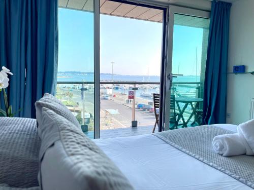 浦耳Quay & Sea View Spacious Modern Secure Parking的一间卧室设有一张床和一个大型玻璃窗