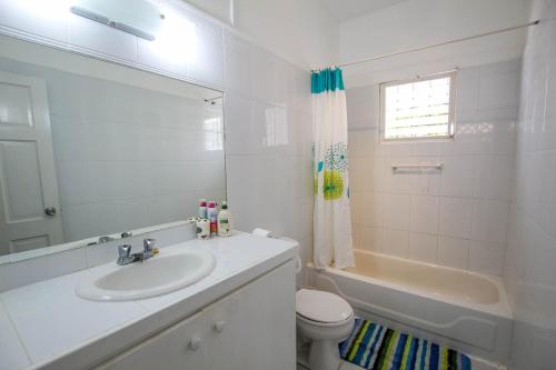 圣詹姆斯2 minute walk to Beach & Pool - Casual 2-Bed House home的浴室配有盥洗盆、卫生间和浴缸。