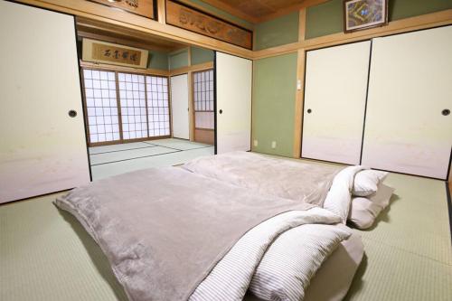 奈良HAT byakugoji, Japanese traditional fireplace　HAT白毫寺　自然豊富な別荘地にある囲炉裏付き一軒家的一间卧室配有一张大床和毛巾