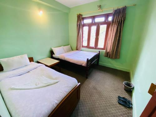 博卡拉HOTEL ICE VIEW POKHARA的小房间设有两张床和窗户