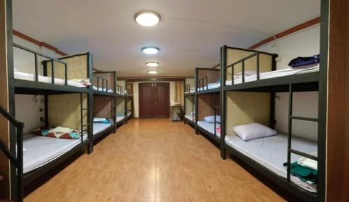 巴色Pakse Backpacker Hostel2023的宿舍的走廊上设有几张双层床